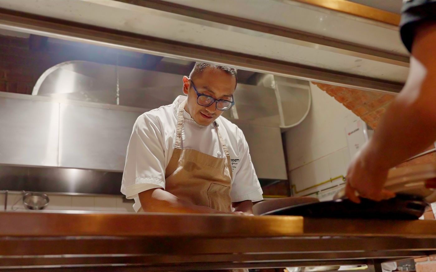 Chef de Los Priostes emplatando en el pase de la cocina durante el servicio
