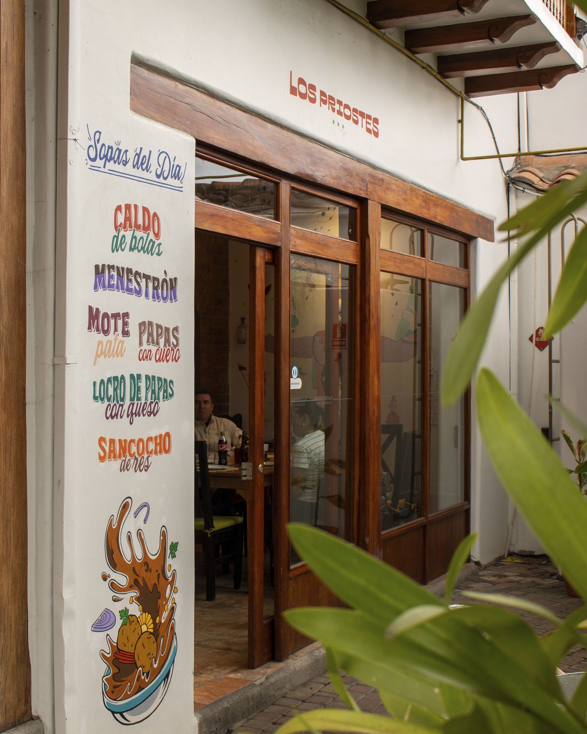 Fachada de Los Priostes en Cuenca con la pizarra de sopas del día pintada a mano